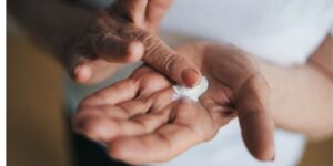 older woman applying skin lotion