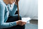aging woman reading a letter, looking concerned