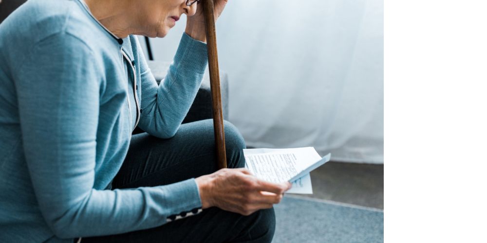 aging woman reading a letter, looking concerned