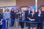JEVS Human Services CEO flanked by SVP of Home Care Katie Brooks and Senior Director of Home Care Beverly Ward are surrounded by attendees as they cut the ribbon to officially open JEVS Care at Home's Dover, DE office